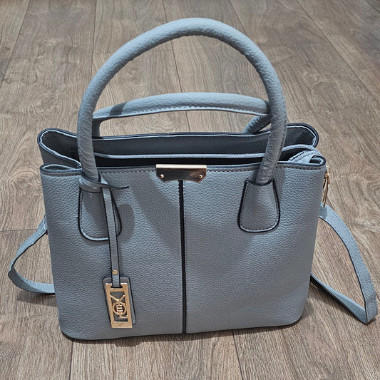 Gray handbag with a gold tag on a wooden floor