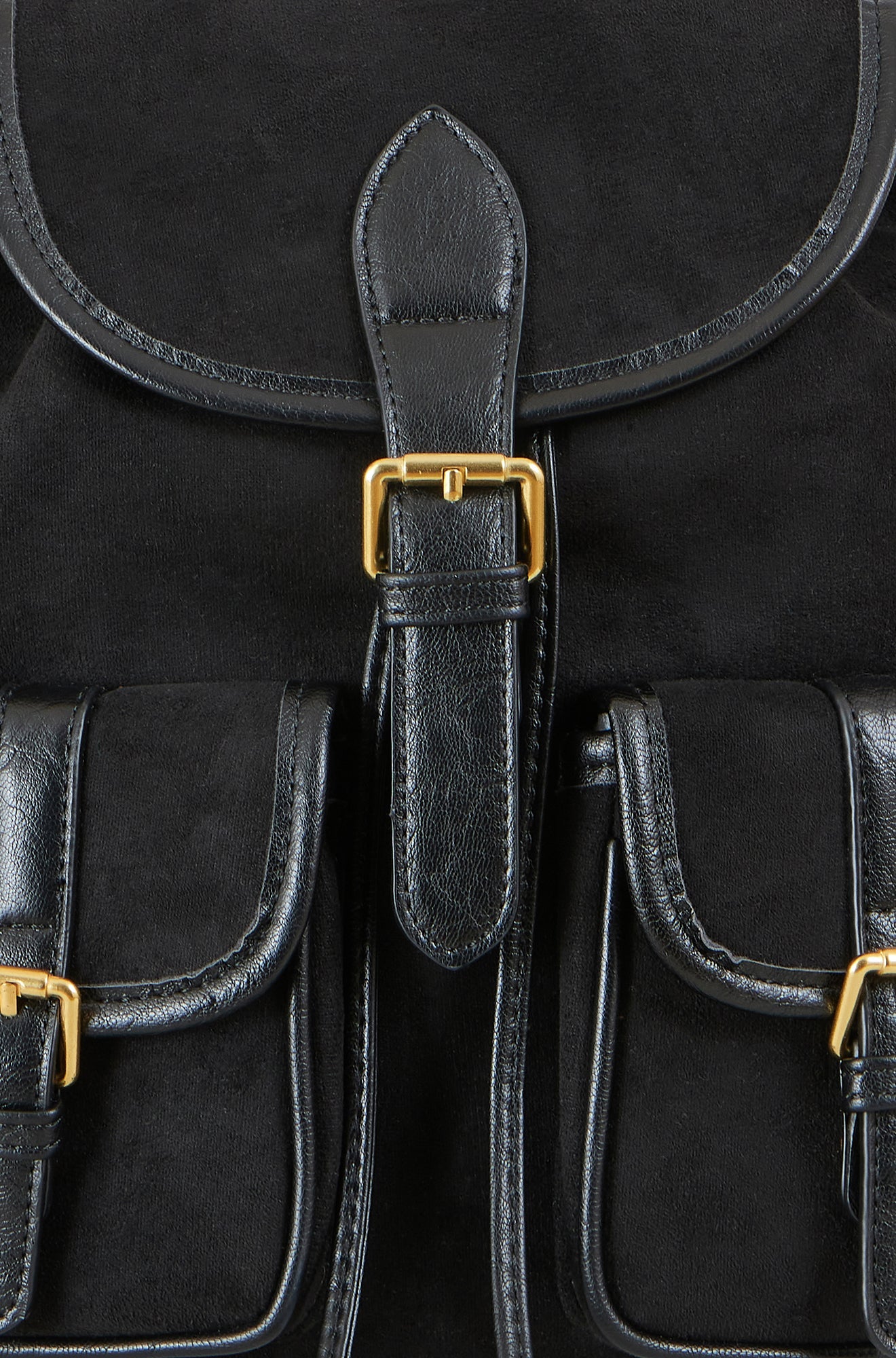 Black leather satchel with gold buckles on a black background