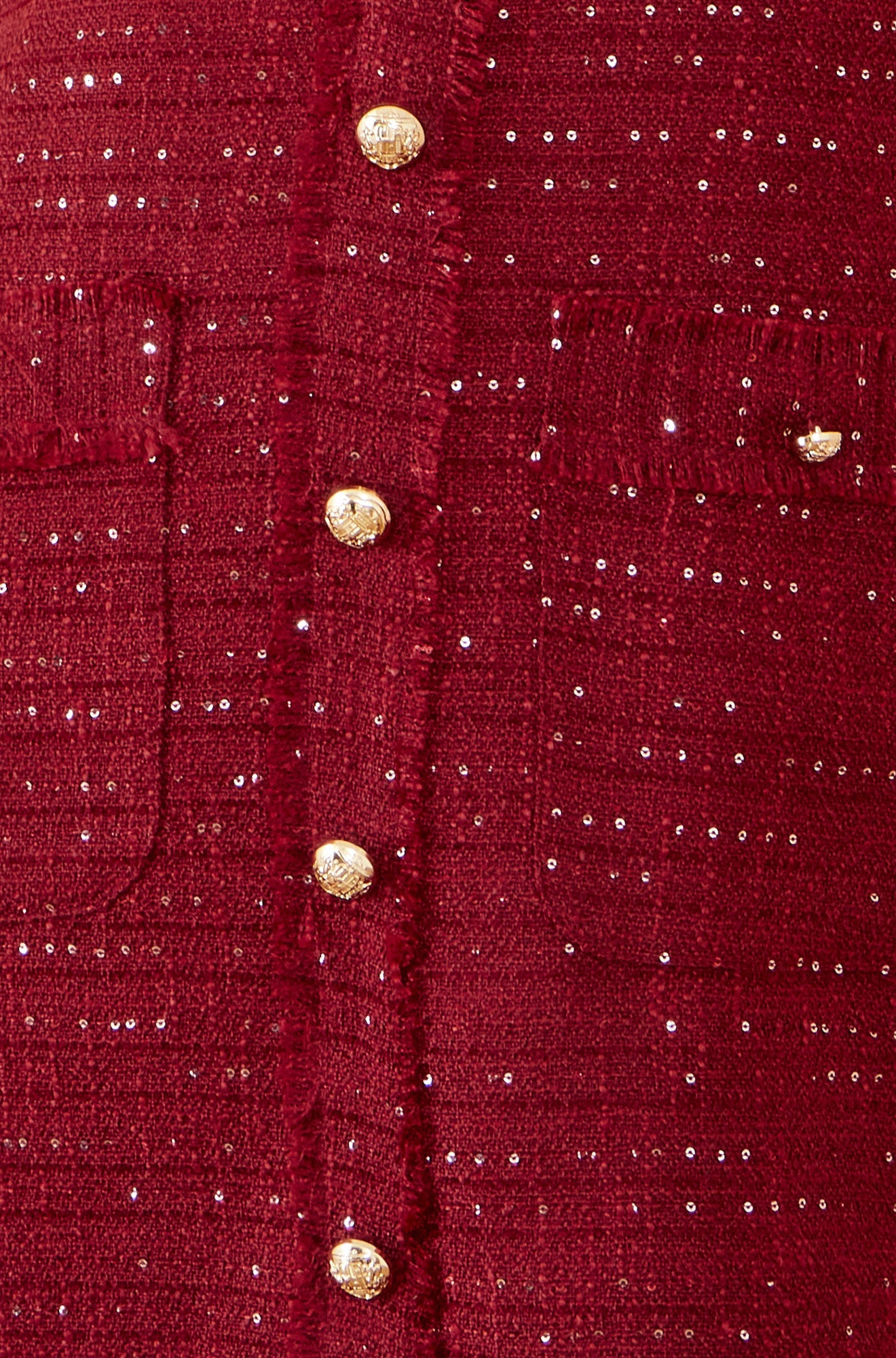 Close-up of a red textured fabric with gold buttons
