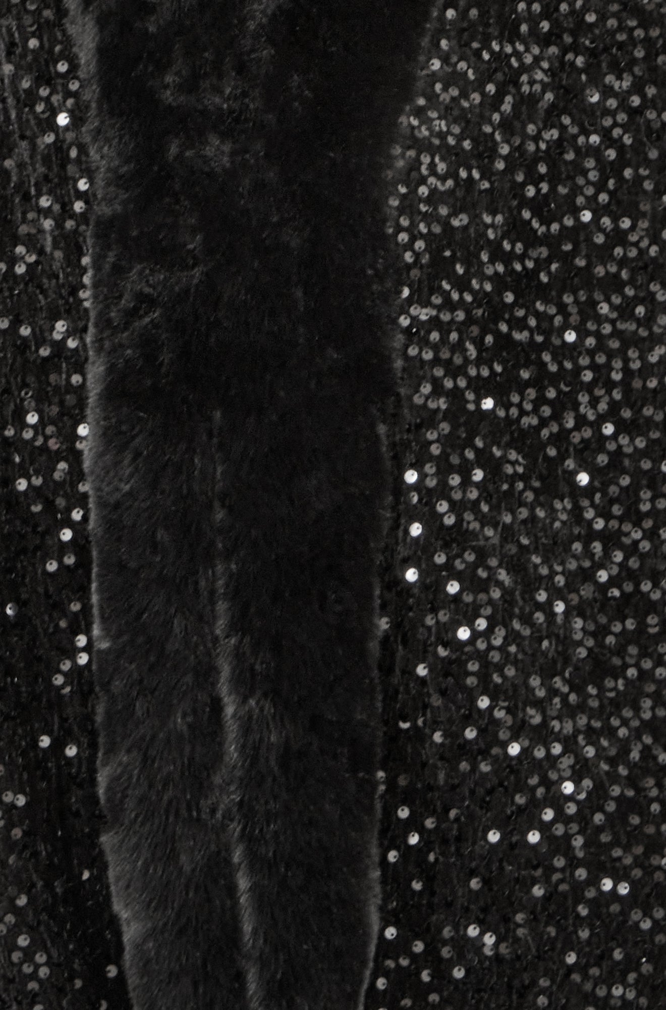 Close-up of a textured black fabric with a sequined background