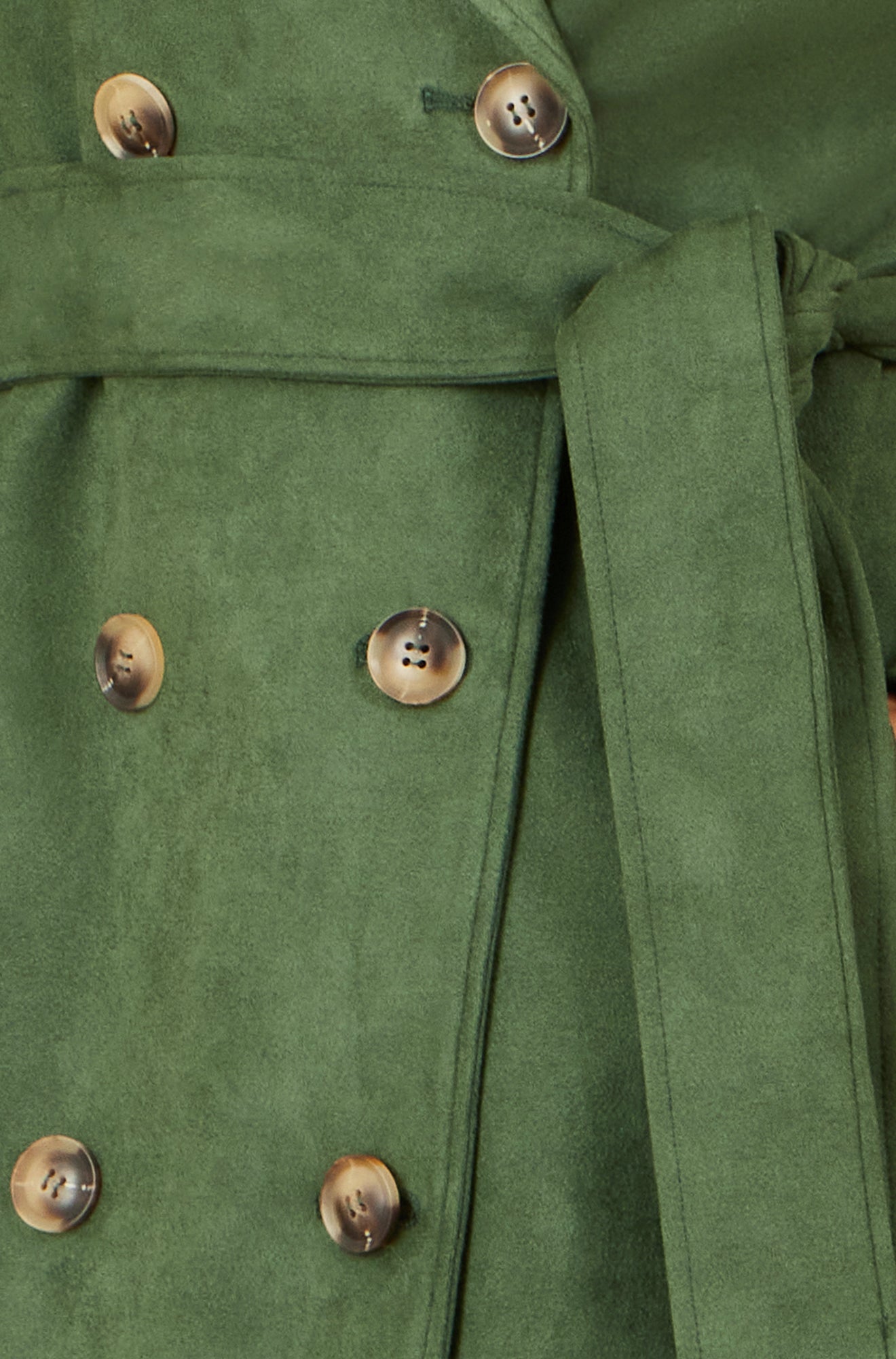 Close-up of a green coat with buttons on a blurred background