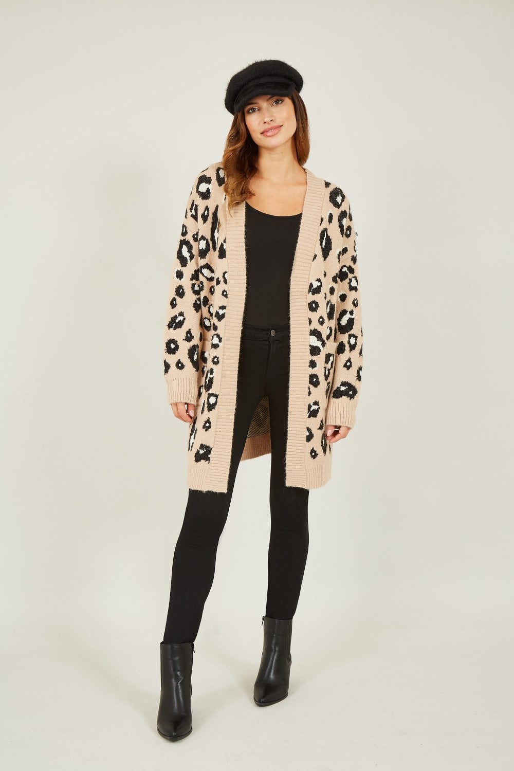 Woman wearing a leopard print cardigan on a white background